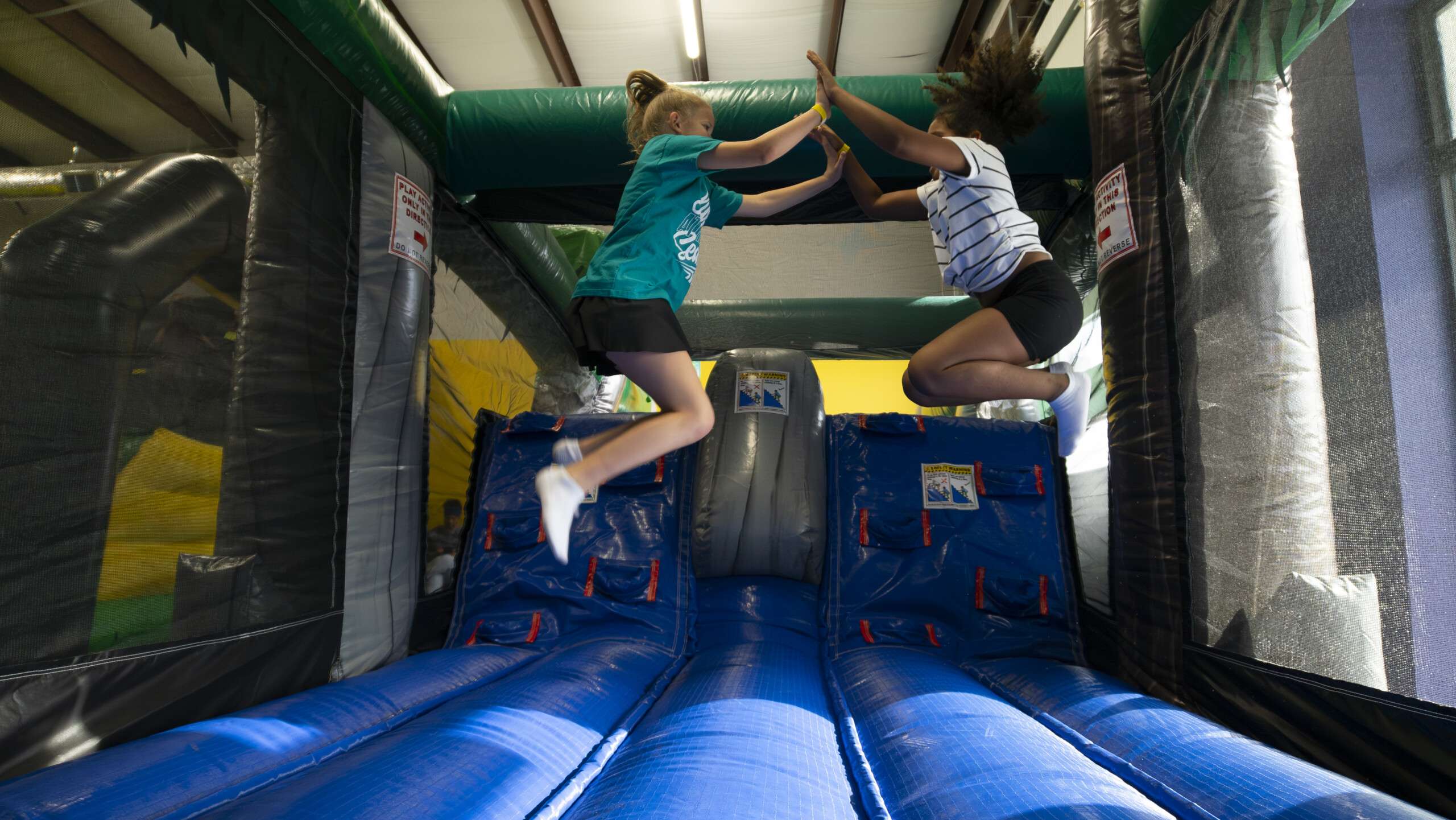 Best friends having fun with inflatable bouncy castle at Bounce Owasso